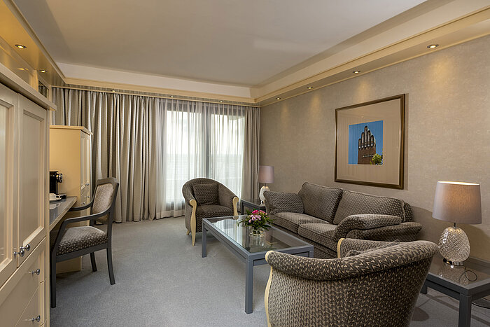 Elegante Suite im Maritim Hotel Darmstadt mit geräumigem Wohnzimmer und stilvollen Möbeln.