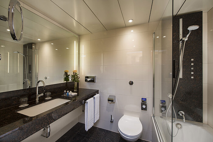 Geräumiges Bad mit Dusche, WC, Spiegel und Granitwaschtisch im Maritim Hotel Stuttgart