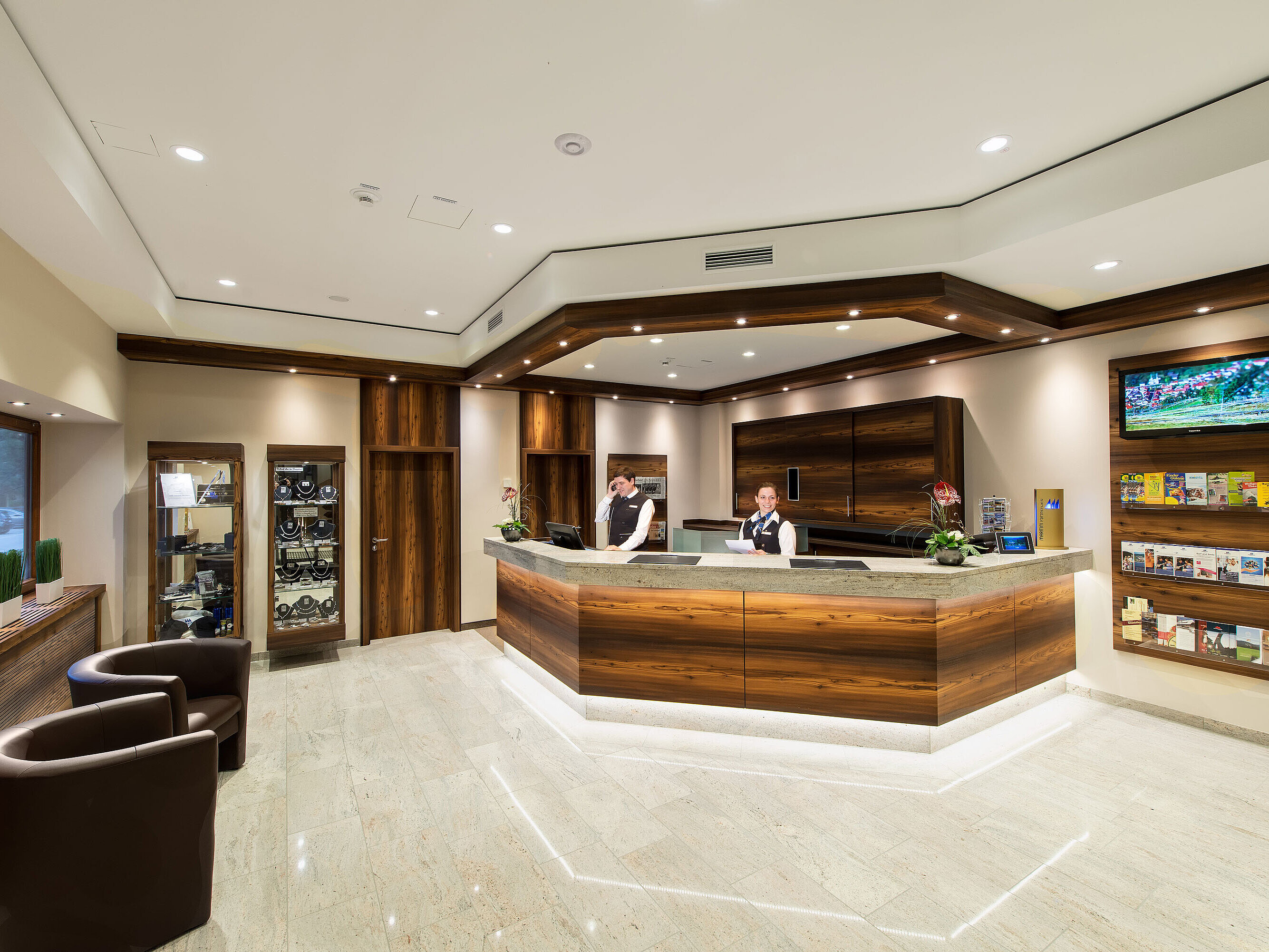Moderner Empfangsbereich im Maritim Hotel Titisee mit Holzdetails und freundlichem Personal an der Rezeption