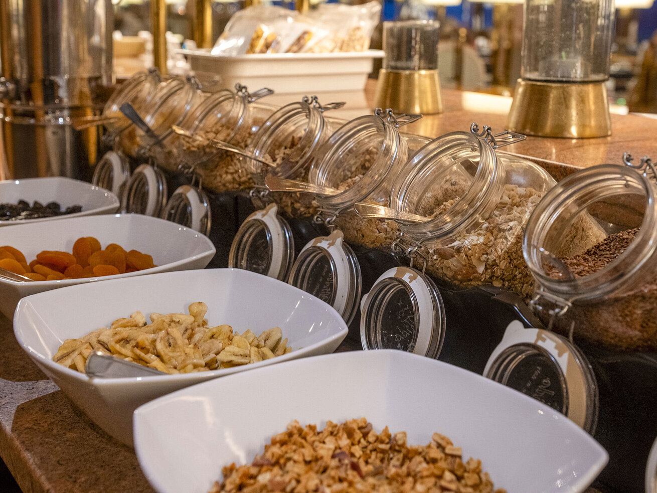 Auswahl an verschiedenen Cerealien, Nüssen und Frühstücksflocken am Frühstücksbuffet.