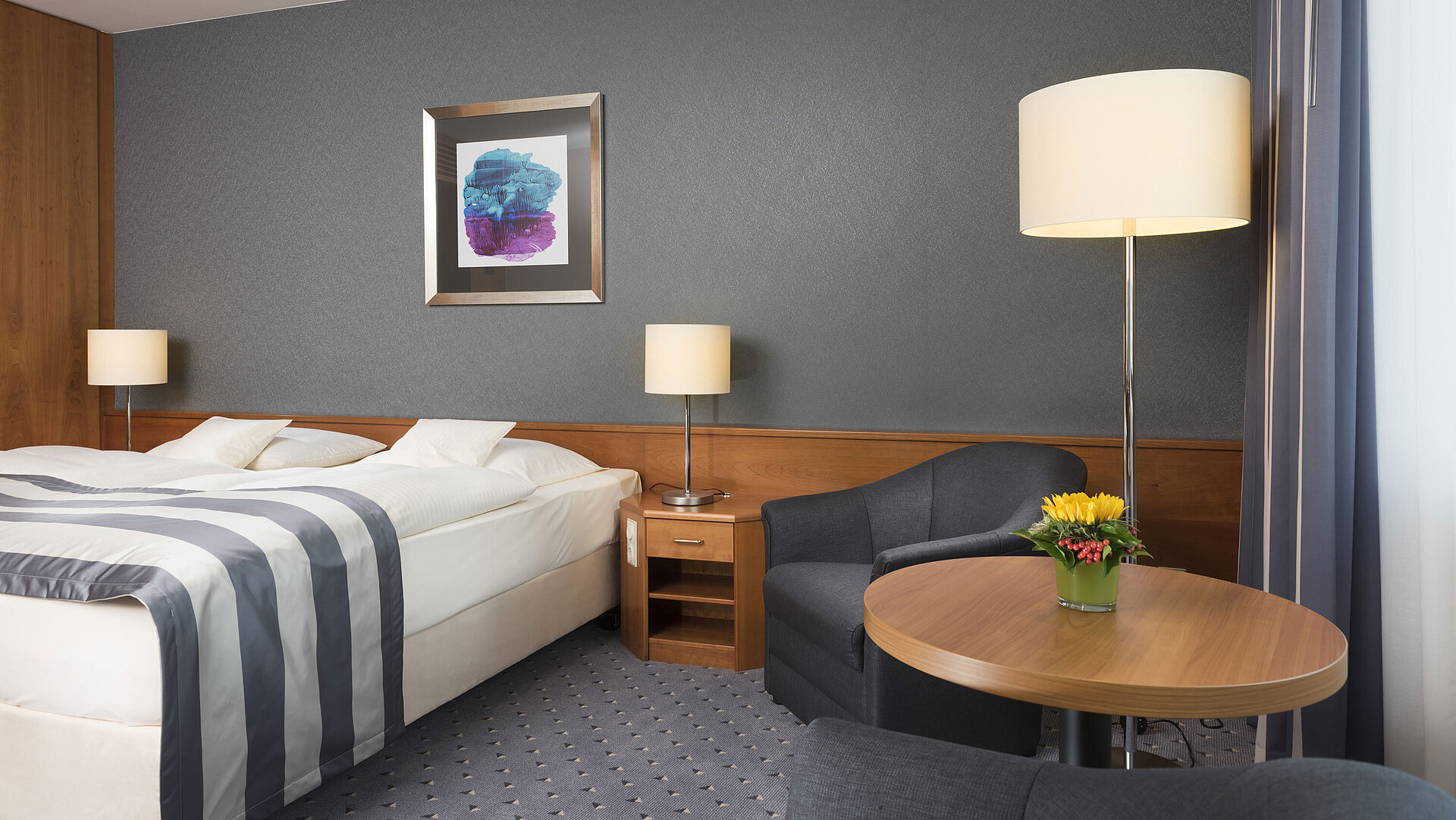 Komfortables Hotelzimmer im Maritim Hotel Ulm mit Doppelbett, Sitzbereich und stilvoller Einrichtung