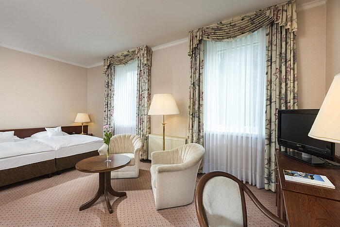 Großes Doppelzimmer mit zwei Fenstern und Sitzgruppe im Maritim Hotel Bad Wildungen
