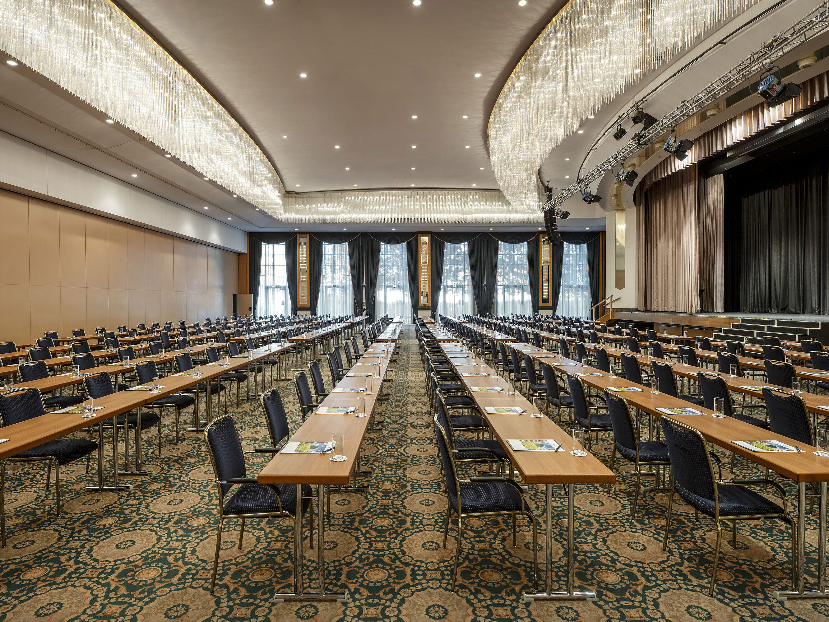 Prächtiger Saal Maritim im Maritim Hotel Magdeburg mit Bühne, Reihenbestuhlung und luxuriösem Kronleuchter.