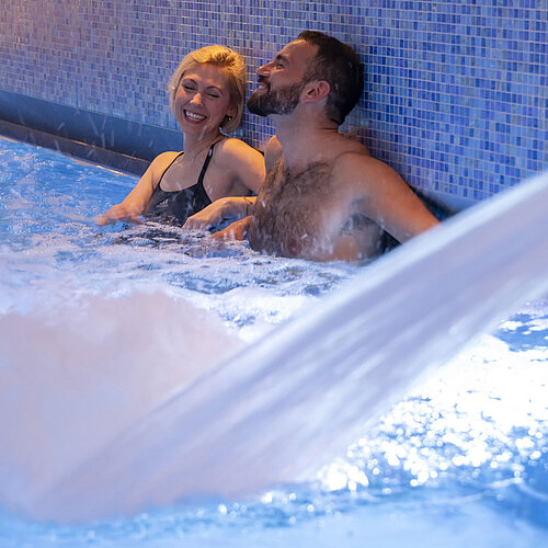 Zwei Gäste genießen den warmen Wasserstrahl im Whirlpool des Maritim Hotel Ingolstadt.