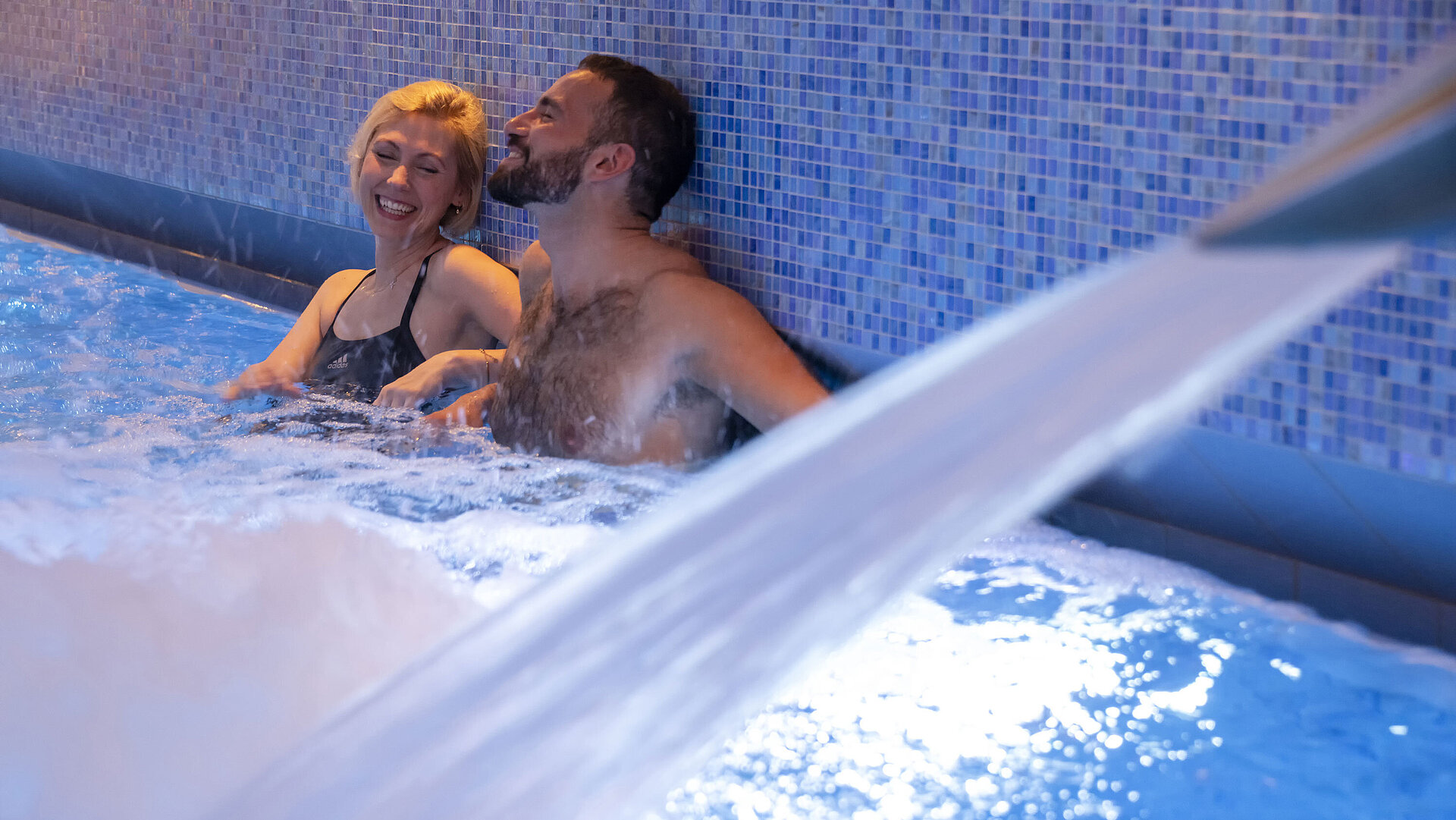 Schwimmbad Zwei Gäste genießen den warmen Wasserstrahl im Whirlpool des Maritim Hotel Ingolstadt.
