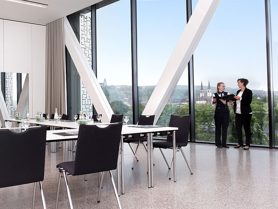 Moderner Tagungsraum im Maritim Hotel Würzburg mit großem Fenster, Ausblick und zwei sprechenden Personen