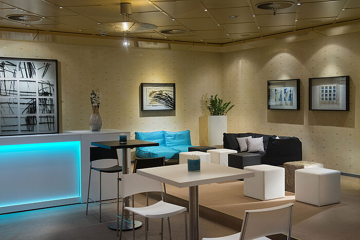 Moderne Lounge mit Sitzgelegenheiten und Bar im Maritim proArte Hotel Berlin, ideal für Meetings und Networking.