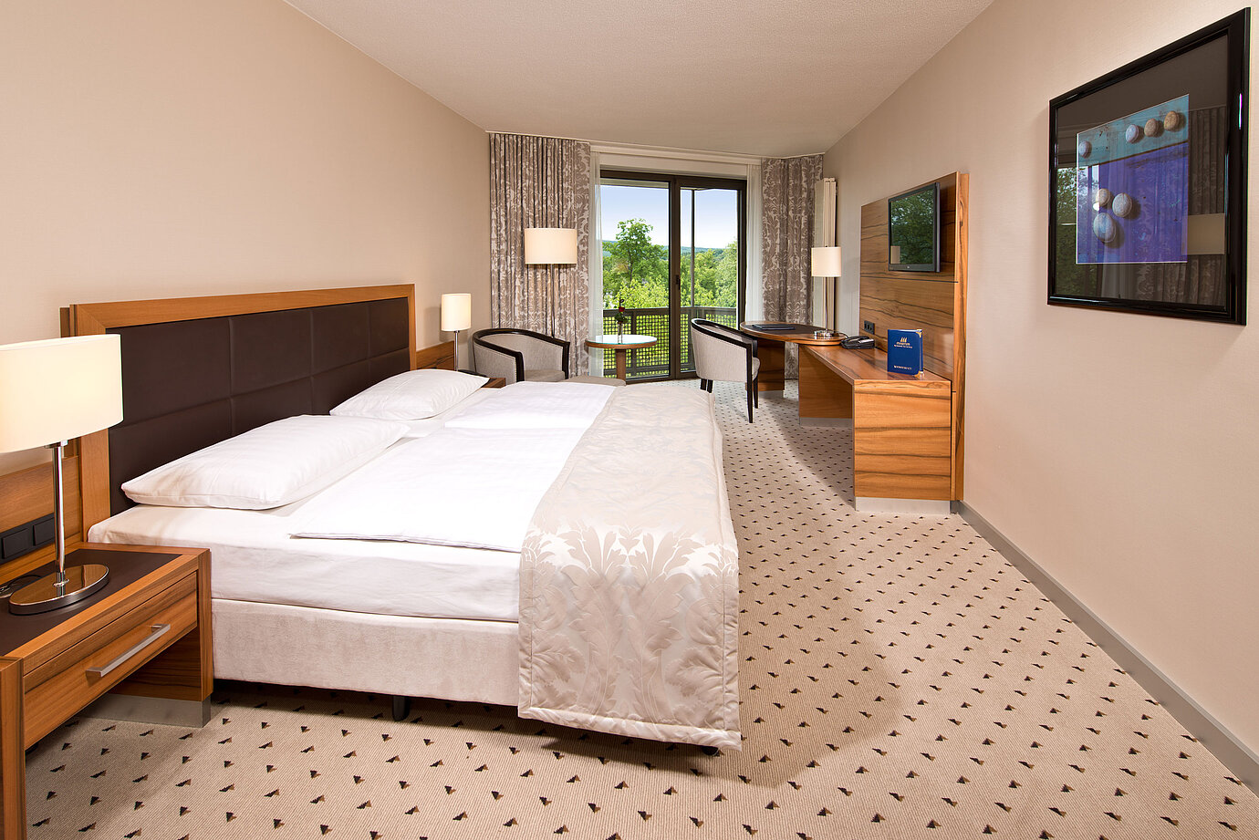Helles Zimmer im Maritim Hotel Bad Homburg mit gemütlichem Bett, Schreibtisch und Balkon mit grünem Ausblick.