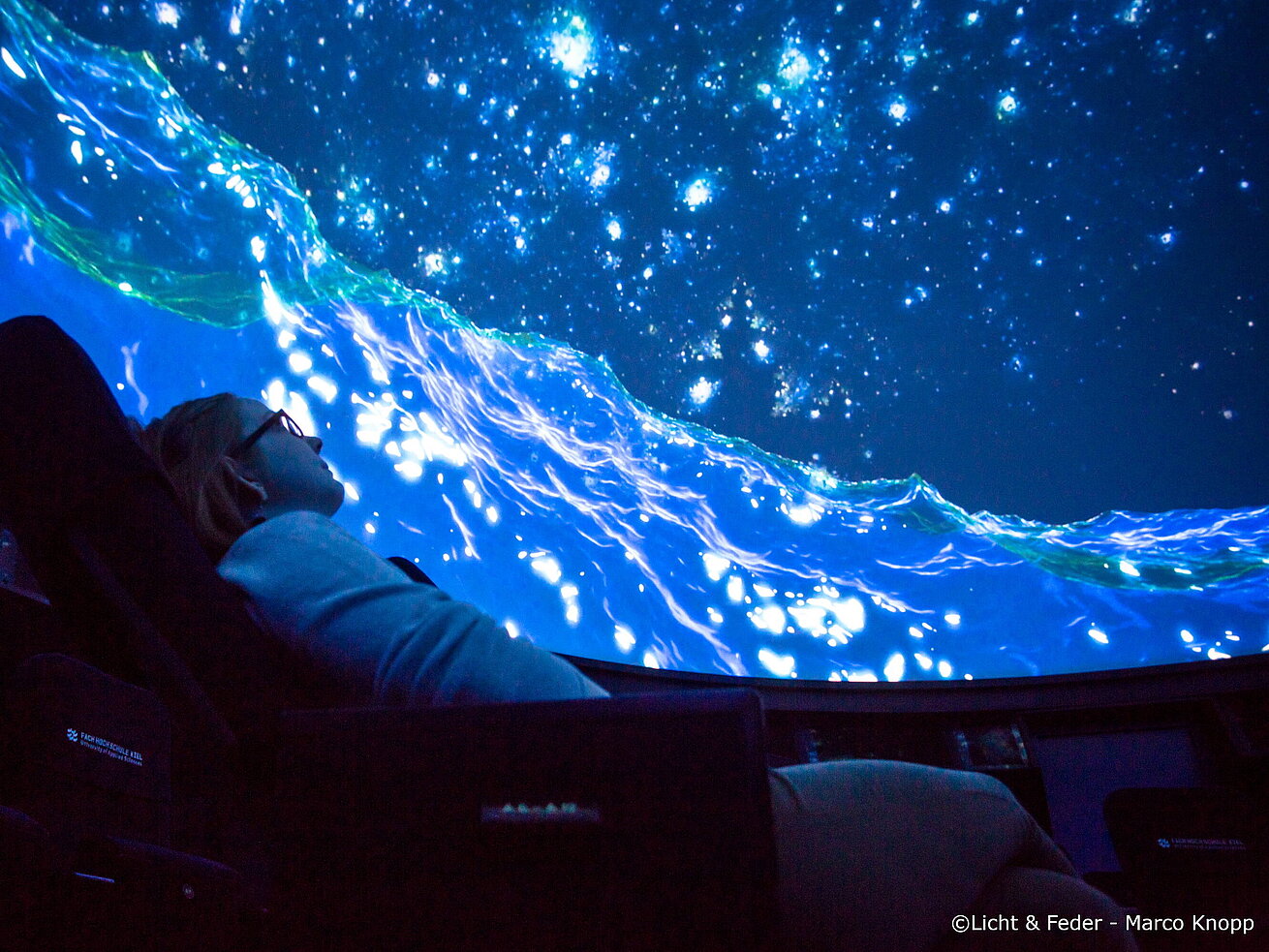 Im Mediendom bei laufender Show Person im Planetarium betrachtet Sternenhimmel Projektion mit Weltraumdarstellung
