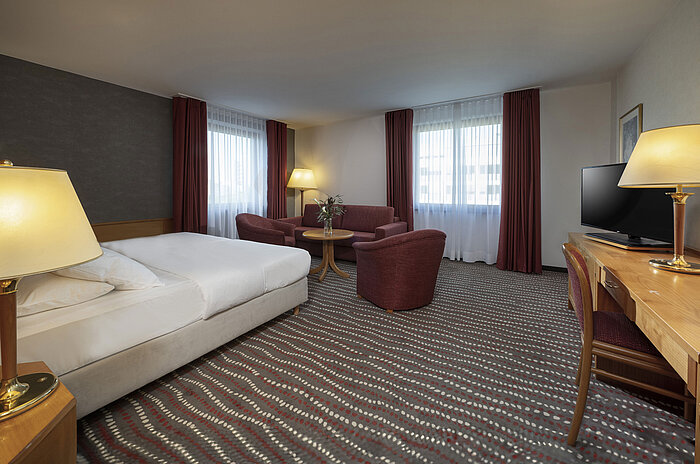Modernes Studiozimmer im Maritim Hotel Magdeburg mit gemütlicher Sitzecke und Doppelbett für einen entspannten Aufenthalt.