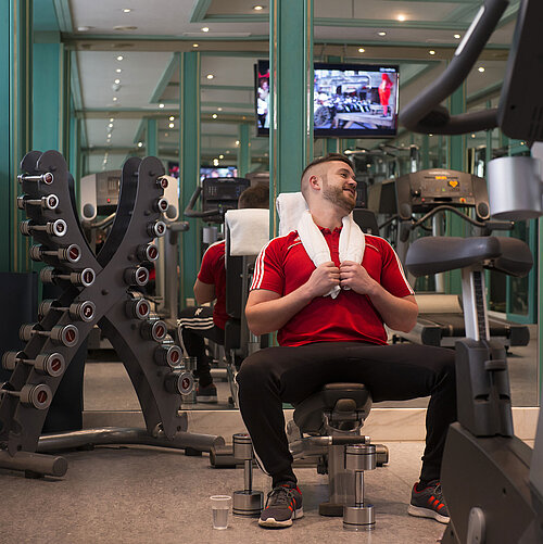Gast im Fitnessraum des Maritim Hotel Stuttgart beim Training mit Hanteln und Geräten