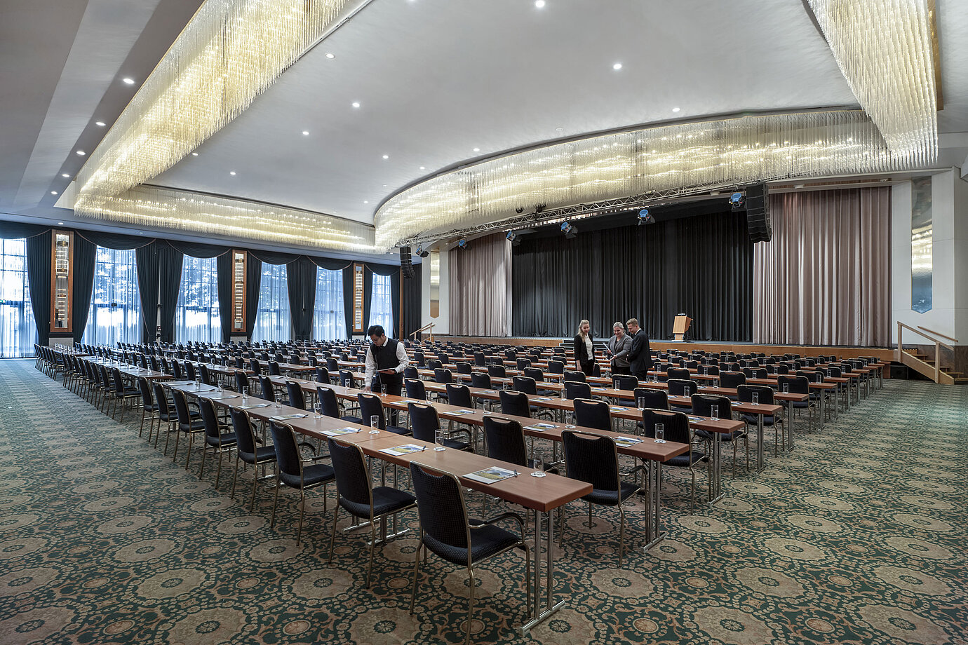 Prächtiger Saal im Maritim Hotel Magdeburg mit Bühne, Reihenbestuhlung und luxuriösem Kronleuchter.