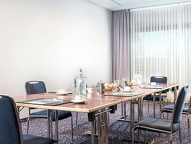 Moderner Konferenzraum im Maritim Hotel Darmstadt mit Tischarrangement, Tageslicht und gedecktem Kaffee-Setup.