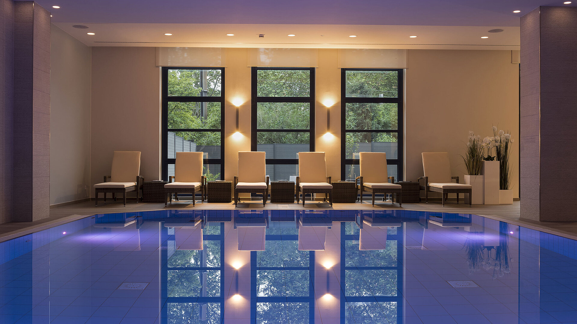 Schwimmbad Poolbereich des Maritim Hotel Bonn mit stilvollen Liegen und beruhigender Beleuchtung für ultimative Entspannung.