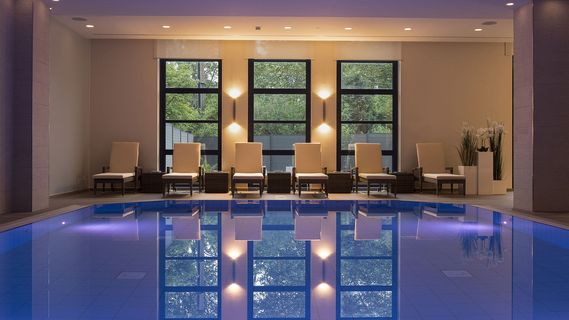 Schwimmbad Poolbereich des Maritim Hotel Bonn mit stilvollen Liegen und beruhigender Beleuchtung für ultimative Entspannung.