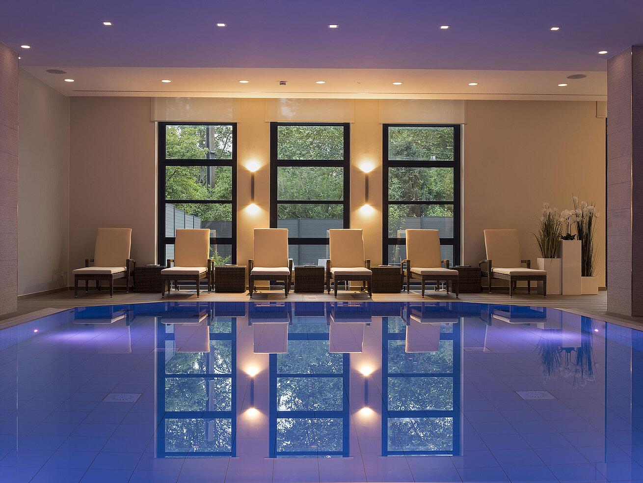Schwimmbad Poolbereich des Maritim Hotel Bonn mit stilvollen Liegen und beruhigender Beleuchtung für ultimative Entspannung.