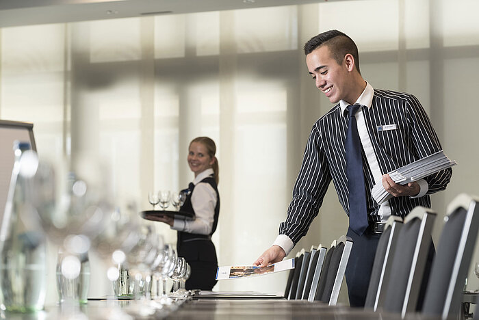 Freundliches Serviceteam im Maritim Hotel Bad Homburg bereitet Tagungsraum vor.