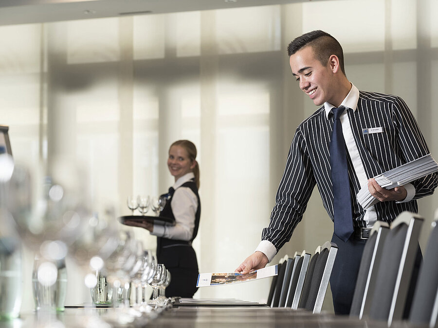 Freundliches Serviceteam im Maritim Hotel Bad Homburg bereitet Tagungsraum vor.