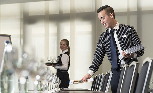 Freundliches Serviceteam im Maritim Hotel Bad Homburg bereitet Tagungsraum vor.