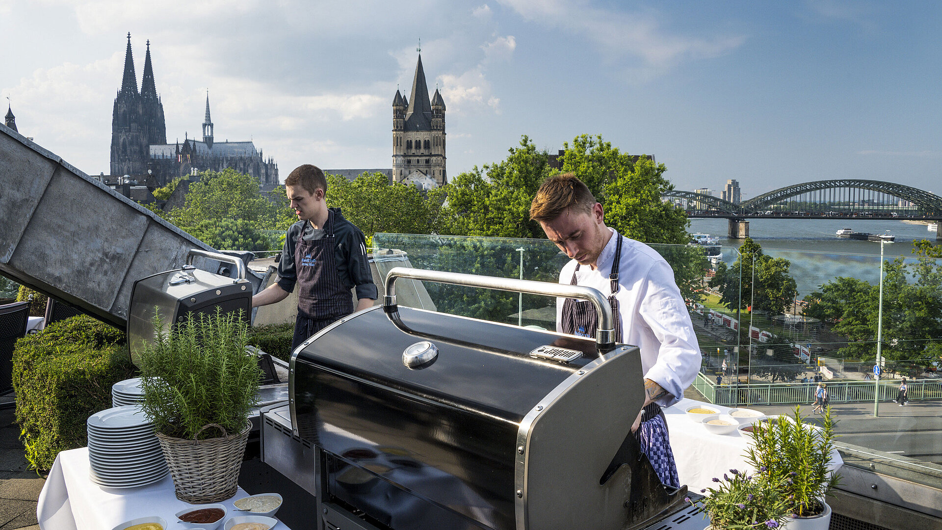 Dachterrasse Dachterrasse des Maritim Hotels Köln mit Blick auf den Dom und die Hohenzollernbrücke. Köche bereiten ein BBQ vor.