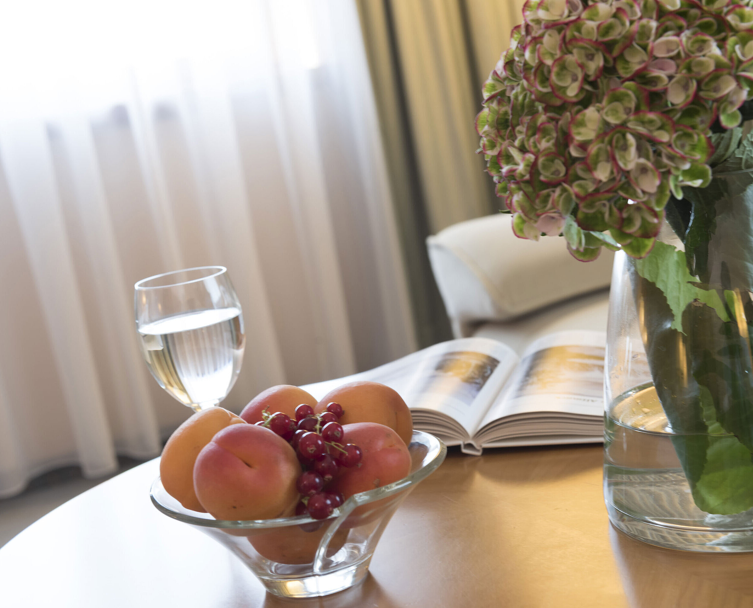 Glas Wasser, Obstschale und Vase mit Hortensie auf dem Tisch im Maritim Hotel Magdeburg