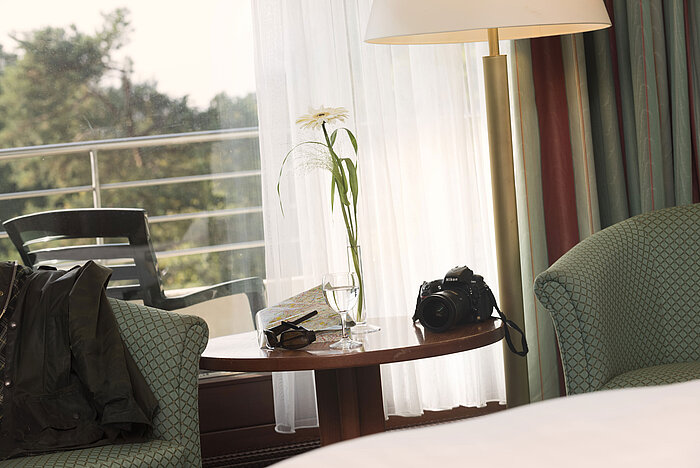 Tisch mit Kamera, Stadtplan und Glas im Maritim Hotel Bad Salzuflen mit Blick auf den Balkon