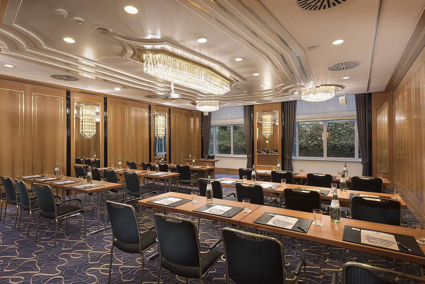 Reihenbestuhlter Tagungsraum mit Tageslicht, Kronleuchtern und Schreibutensilien im Maritim Hotel Stuttgart