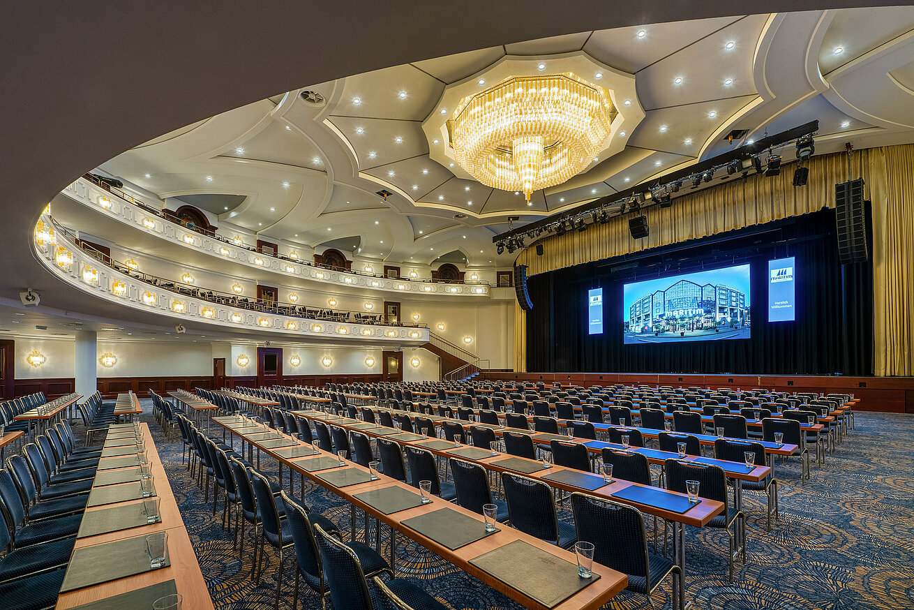 Großer Saal im Maritim Hotel Köln mit Bühne, Kronleuchter und Reihenbestuhlung