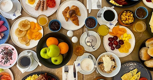 Reichhaltiges Frühstück im Les Jardins Restaurant des Maritim Antonine Hotel & Spa Malta mit Eierspeisen, Pancakes, Croissants, Obst, Joghurt, Müsli, Säften und Kaffee.