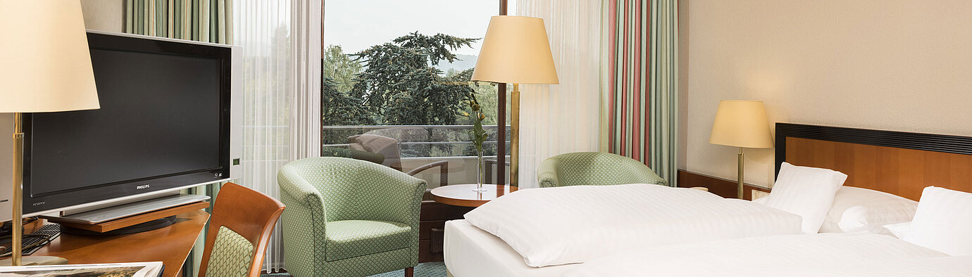 Superior Zimmer Helles Hotelzimmer im Maritim Hotel Bad Salzuflen mit Doppelbett, Sitzbereich und Zugang zum Balkon mit Ausblick