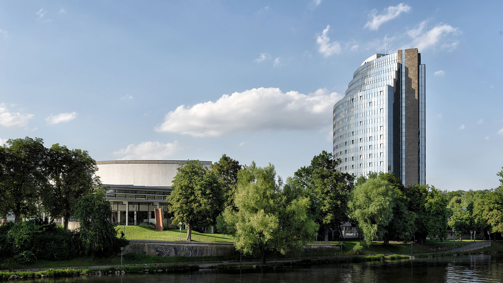 Maritim Hotel Ulm mit Blick auf die Donau, umgeben von viel Grün und moderner Architektur