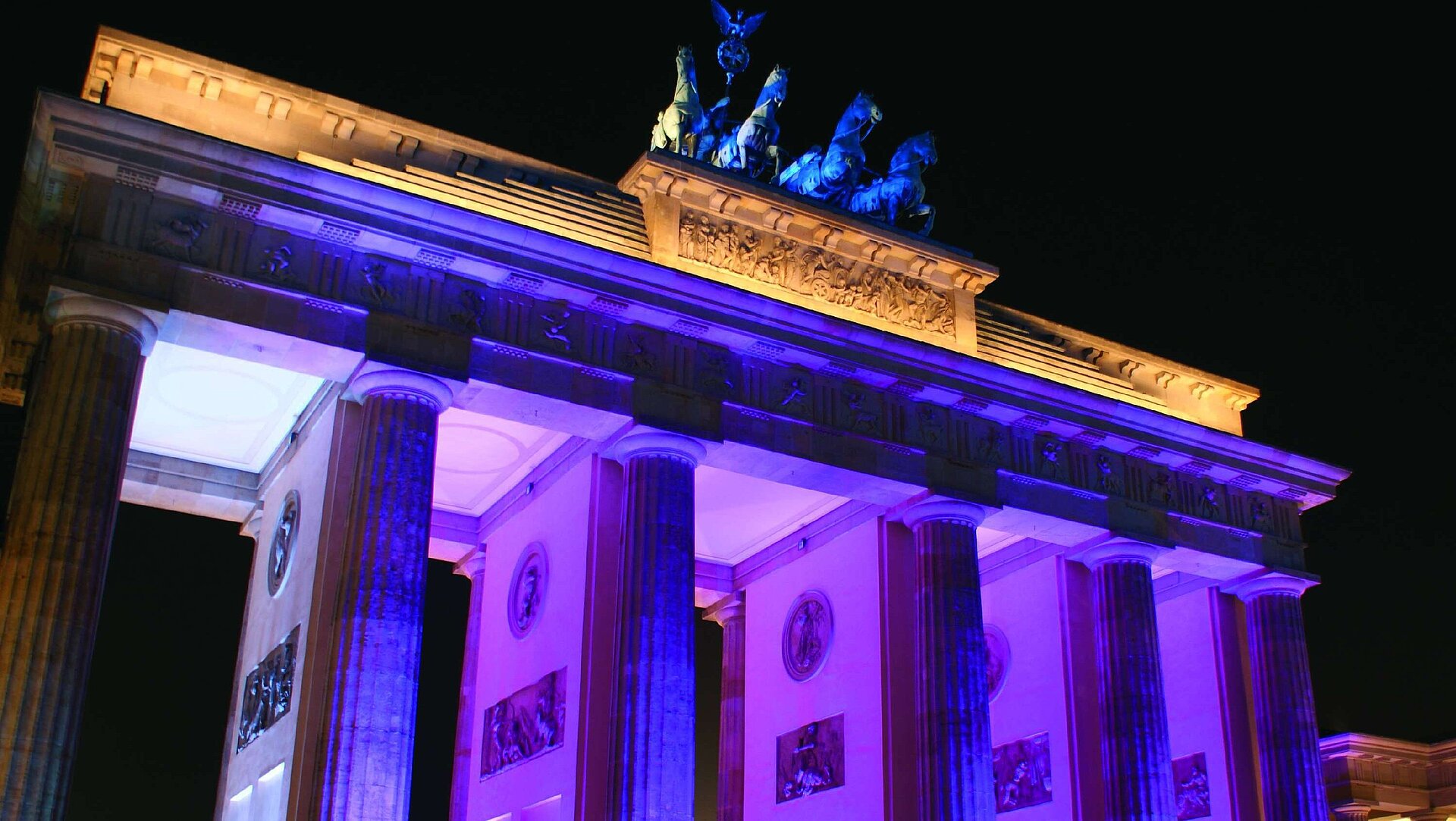 Brandenburger Tor Das Brandenburger Tor bei Nacht in Berlin, beleuchtet in blau-violetten Farben, ein ikonisches Wahrzeichen der Stadt.