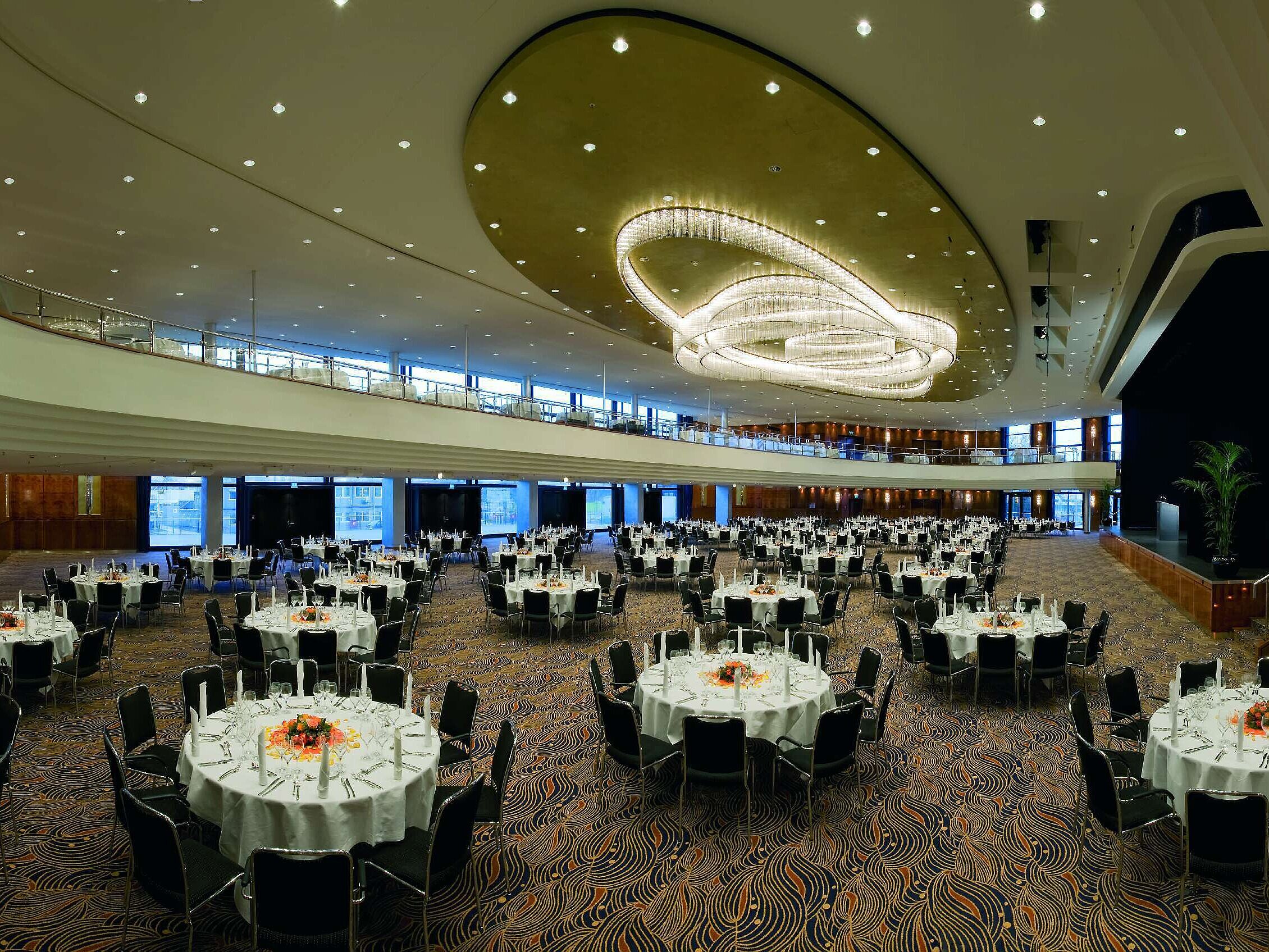Eleganter Veranstaltungssaal im Maritim Hotel Düsseldorf, festlich gedeckt mit runden Tischen und beeindruckender Beleuchtung.