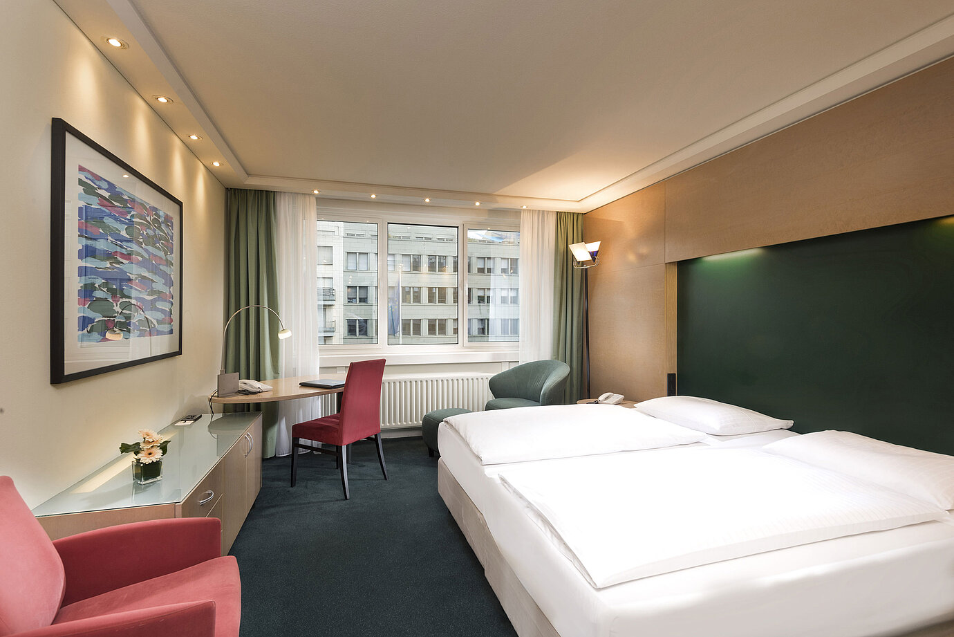 Classic Zimmer im Maritim proArte Hotel Berlin mit Doppelbett, Schreibtisch und Blick auf umliegende Gebäude.