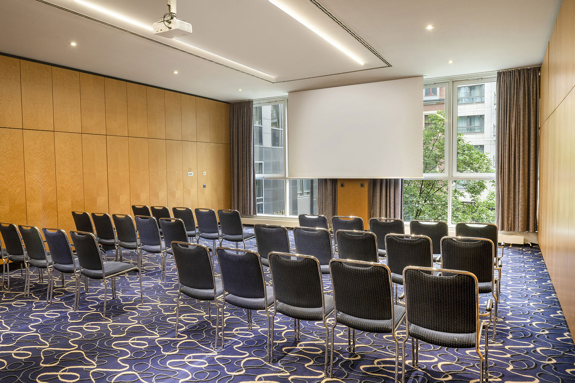 Salon 6 Moderner Tagungsraum im Maritim proArte Hotel Berlin mit Stuhlreihen und Leinwand.