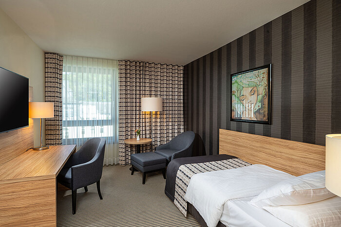 Classic Einzelzimmer Classic Einzelzimmer im Maritim Hotel Königswinter mit Einzelbett, Sitzecke und großem Fenster.