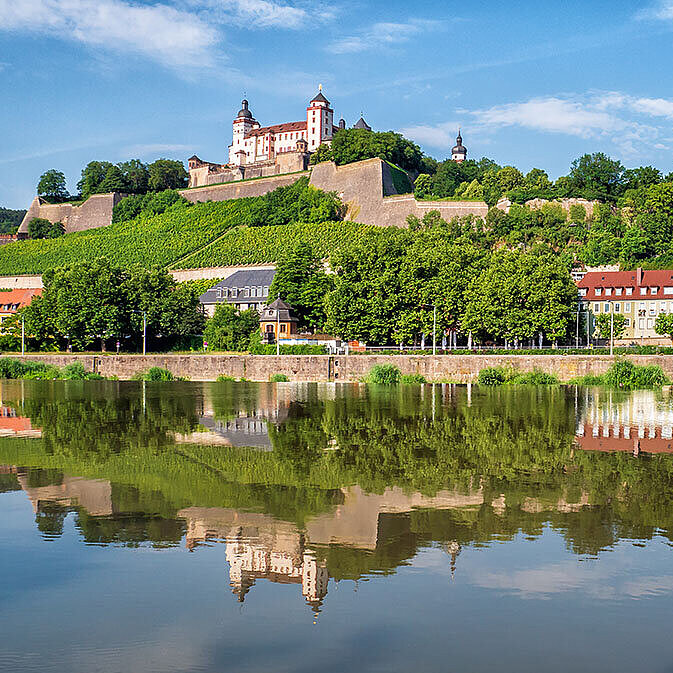 Panorama von Würzburg mit Festung Marienberg, Weinbergen und Spiegelung im Main.