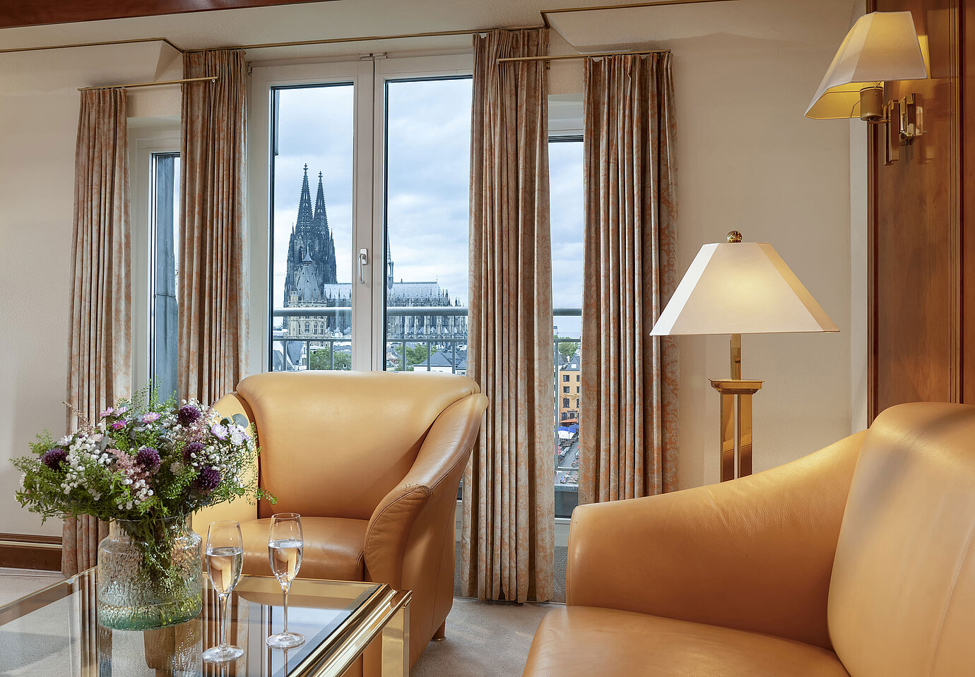 Elegante Heumarkt-Suite im Maritim Hotel Köln mit komfortablen Ledersesseln und direktem Blick auf den Kölner Dom.