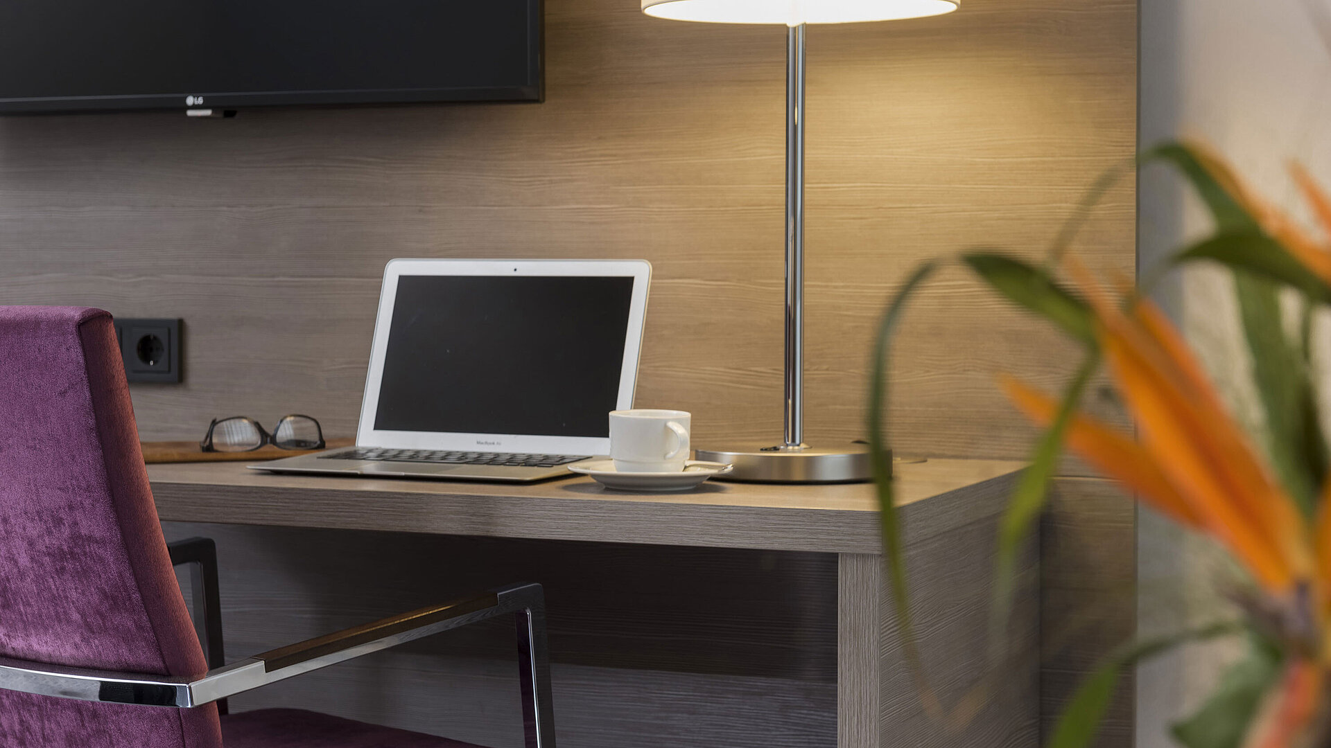 Schreibtisch im Maritim Hotel Königswinter mit Laptop, Lesebrille und eleganter Tischlampe.
