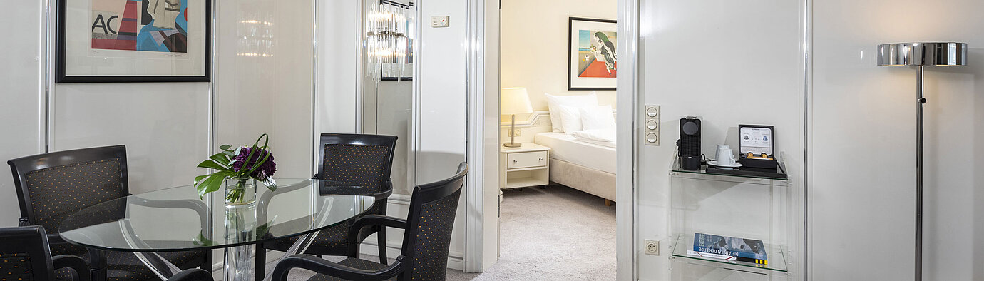 Executive Suite Helle Executive Suite im Maritim Hotel Frankfurt mit stilvollem Essbereich, Glas-Tisch und direktem Zugang zum Schlafzimmer.