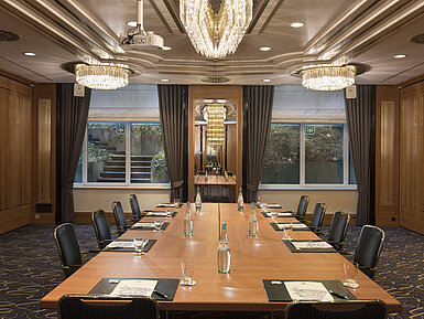Tagungsraum mit großem Konferenztisch, Stühlen und Kronleuchtern im Maritim Hotel Stuttgart