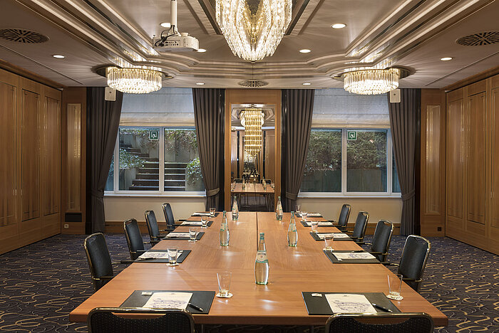Tagungsraum mit großem Konferenztisch, Stühlen und Kronleuchtern im Maritim Hotel Stuttgart