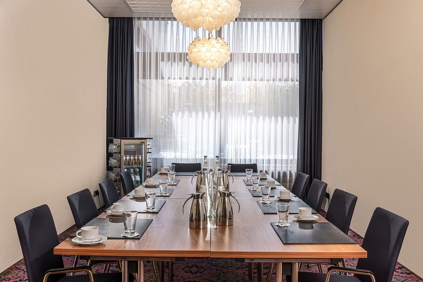Kleiner Konferenzraum mit Fensterfront, Tageslicht und Getränkestation im Maritim Hotel Travemünde
