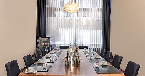 Kleiner Konferenzraum mit Fensterfront, Tageslicht und Getränkestation im Maritim Hotel Travemünde