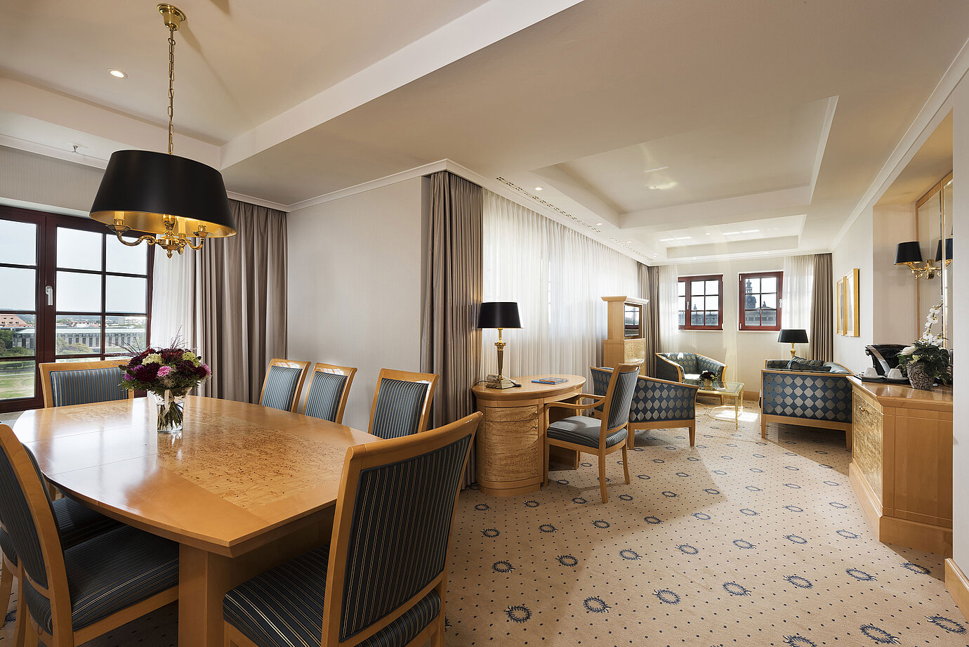 Geräumige Executive Suite im Maritim Hotel Dresden mit elegantem Esstisch, komfortabler Sitzecke und Blick auf die Stadt.