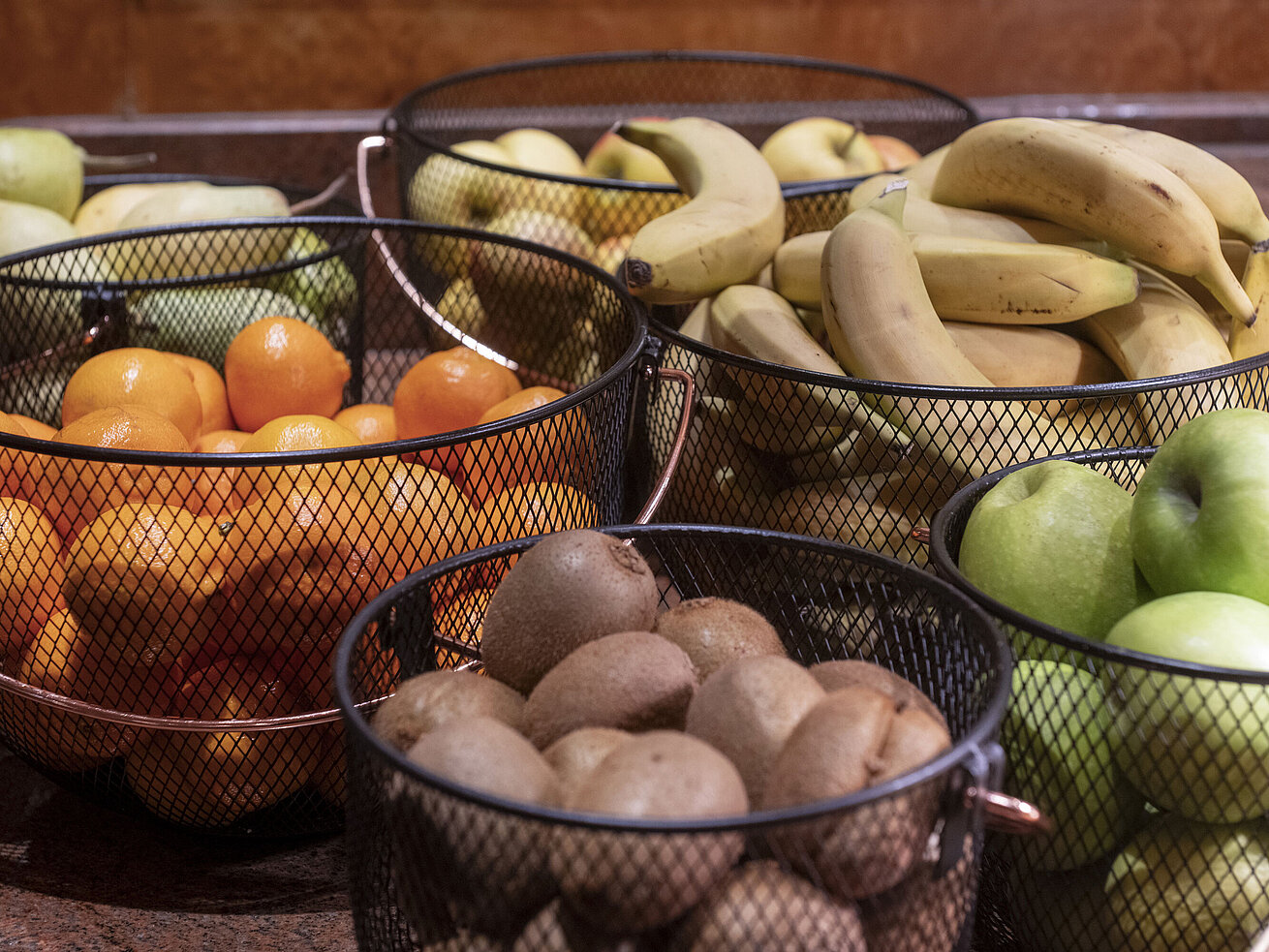 Verschiedene frische Obstsorten in Körben am Frühstücksbuffet.