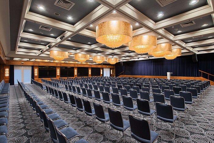 Eleganter Saal im Maritim Hotel Darmstadt mit Reihenbestuhlung, Kronleuchtern und idealer Ausstattung für Events.