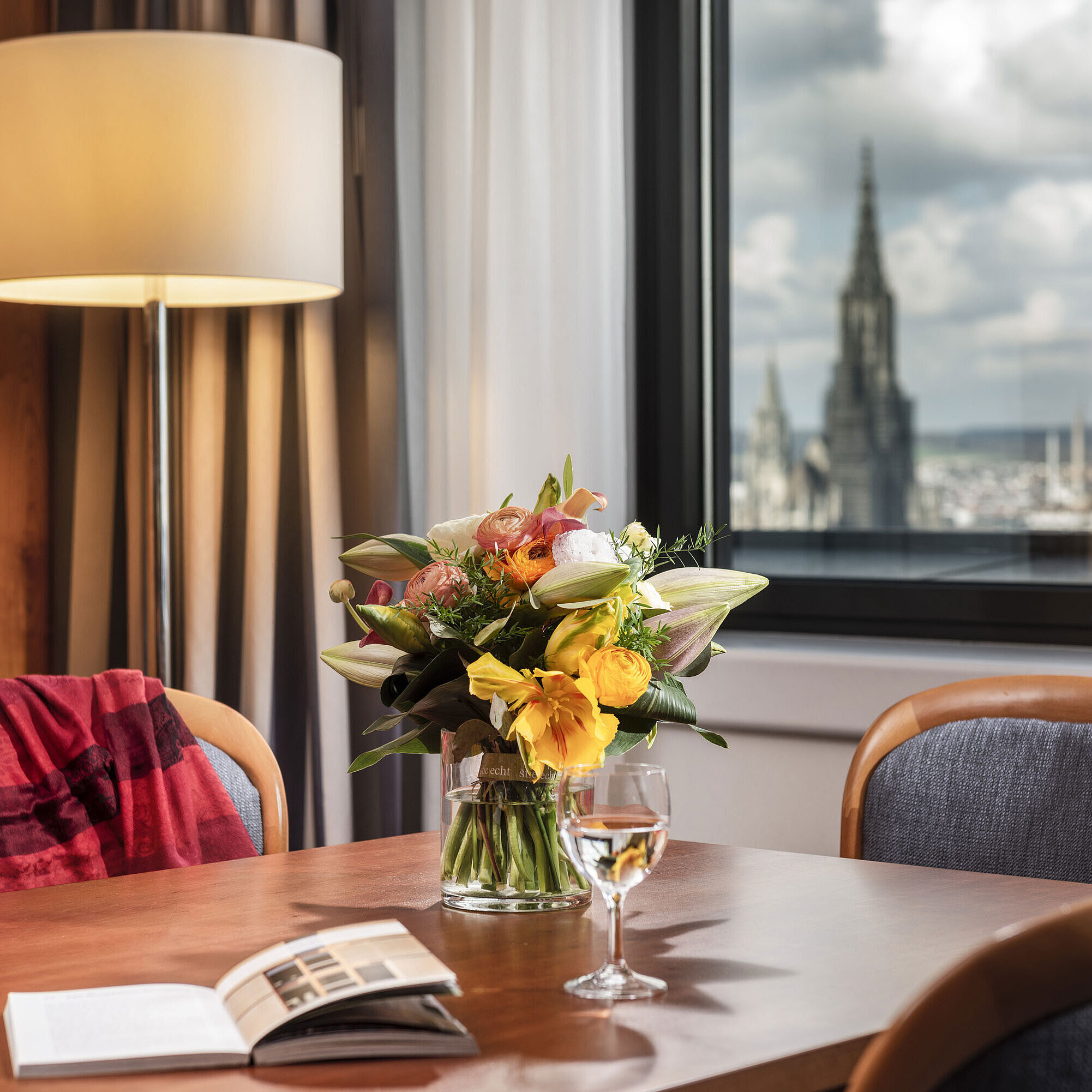 Tisch mit Blumenstrauß in der Junior Suite im Maritim Hotel Ulm mit Blick auf das Ulmer Münster