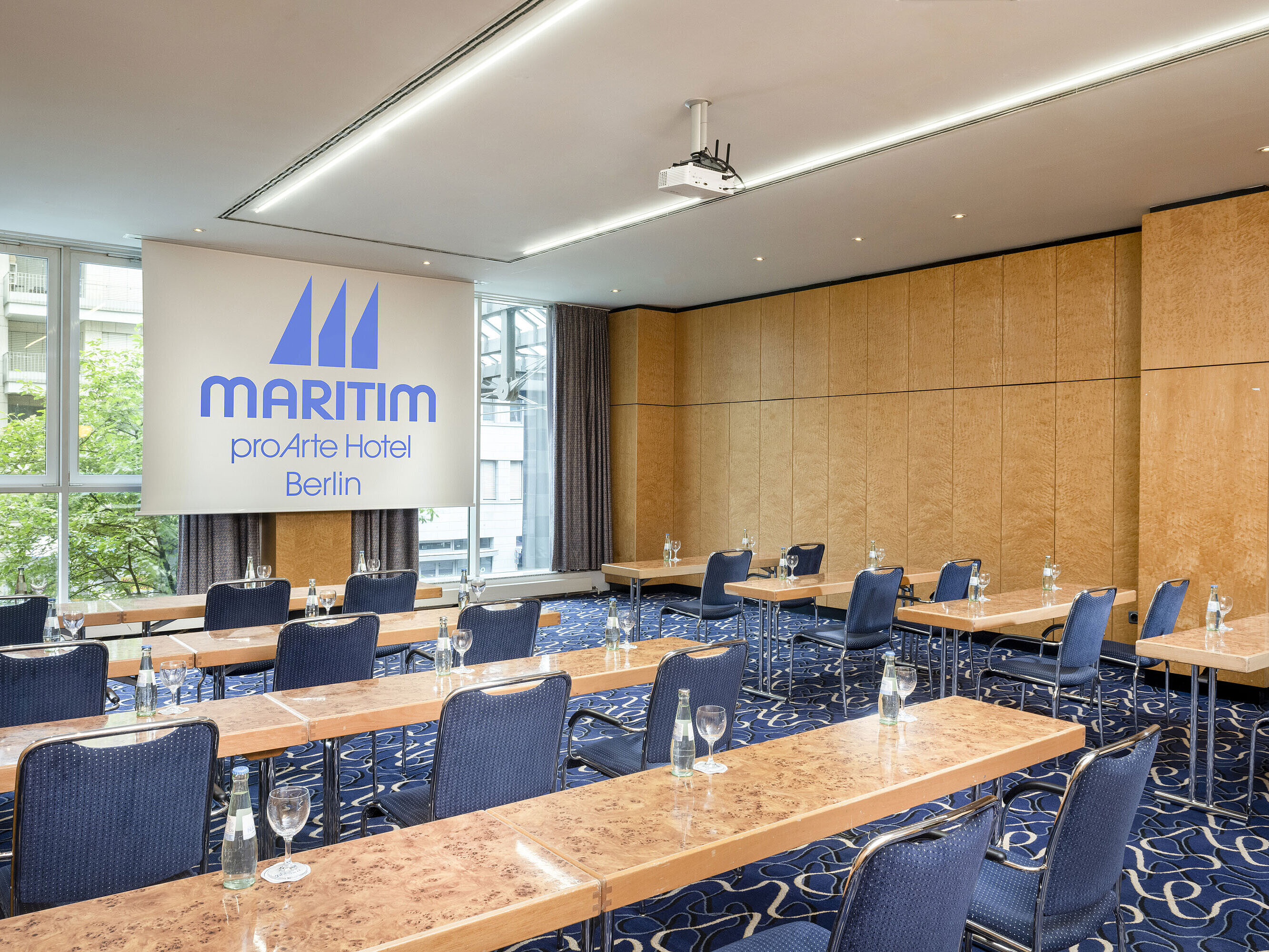 Konferenzraum im Maritim proArte Hotel Berlin mit Reihenbestuhlung und Projektionsfläche.