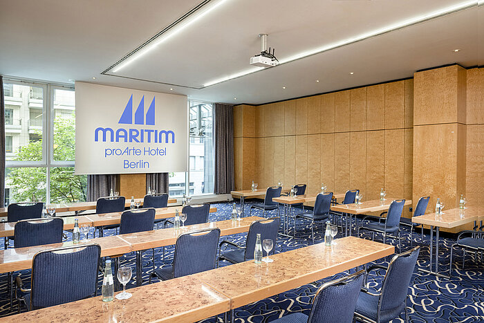 Konferenzraum im Maritim proArte Hotel Berlin mit Reihenbestuhlung und Projektionsfläche.